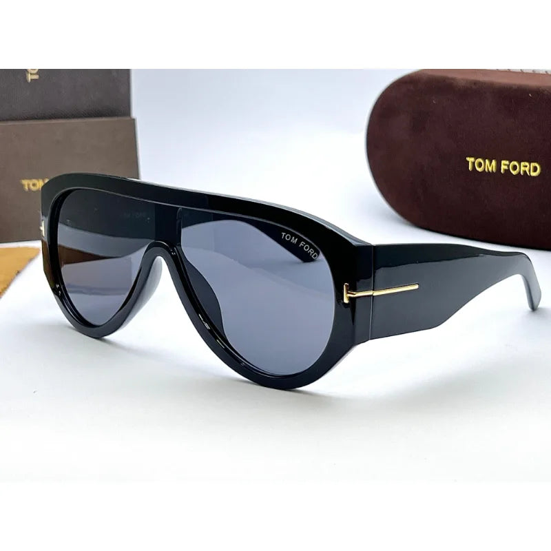 Close-up of Tom Ford Bronson black sunglasses side view showing signature gold T logo on temples